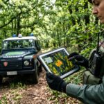 Un ufficiale dei Carabinieri Forestali analizza i dati termici del territorio su un tablet durante un pattugliamento preventivo.