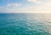 Il respiro affannoso del Mediterraneo: quando il caldo e la bonaccia frenano la cattura di carbonio Superficie calma del Mar Mediterraneo illuminata dalla luce solare durante una giornata calda