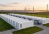 Accumuli energetici, l’Italia rischia il blocco: su 290 GW richiesti solo il 3% supera la burocrazia Impianto industriale di sistemi di accumulo energetico a batteria immerso nel verde