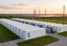 Accumuli energetici, l’Italia rischia il blocco: su 290 GW richiesti solo il 3% supera la burocrazia Impianto industriale di sistemi di accumulo energetico a batteria immerso nel verde