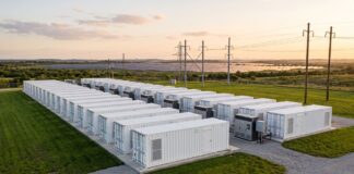 Impianto industriale di sistemi di accumulo energetico a batteria immerso nel verde