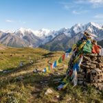 Paesaggio montano incontaminato dell’Asia centrale con pascoli d’alta quota e vette innevate